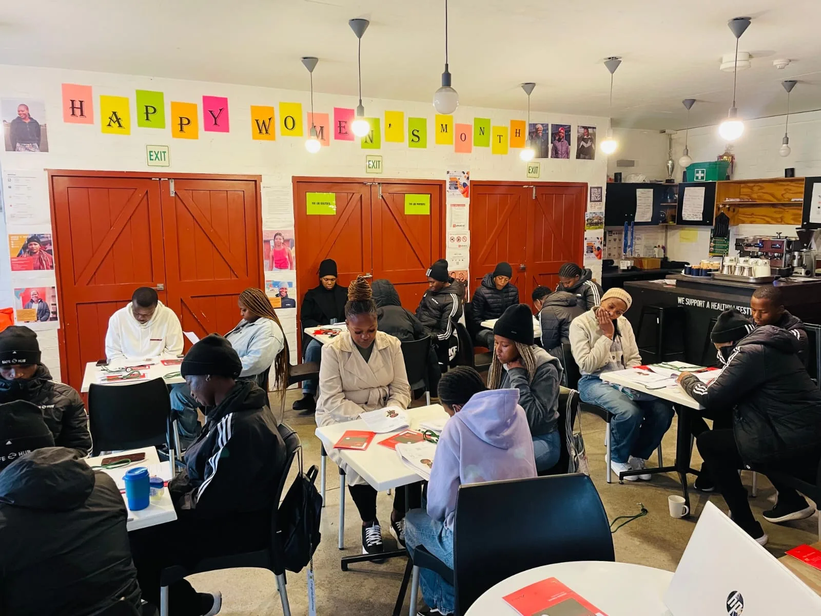 Delegates seated at tables working through FSCA financial literacy workbooks at a NEET workshop