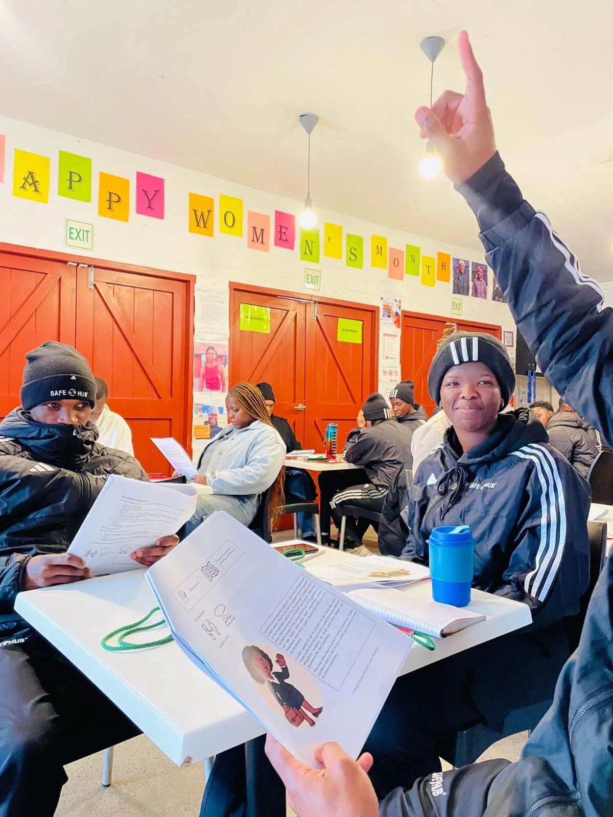 Delegate raising her hand during an FSCA NEET financial literacy session