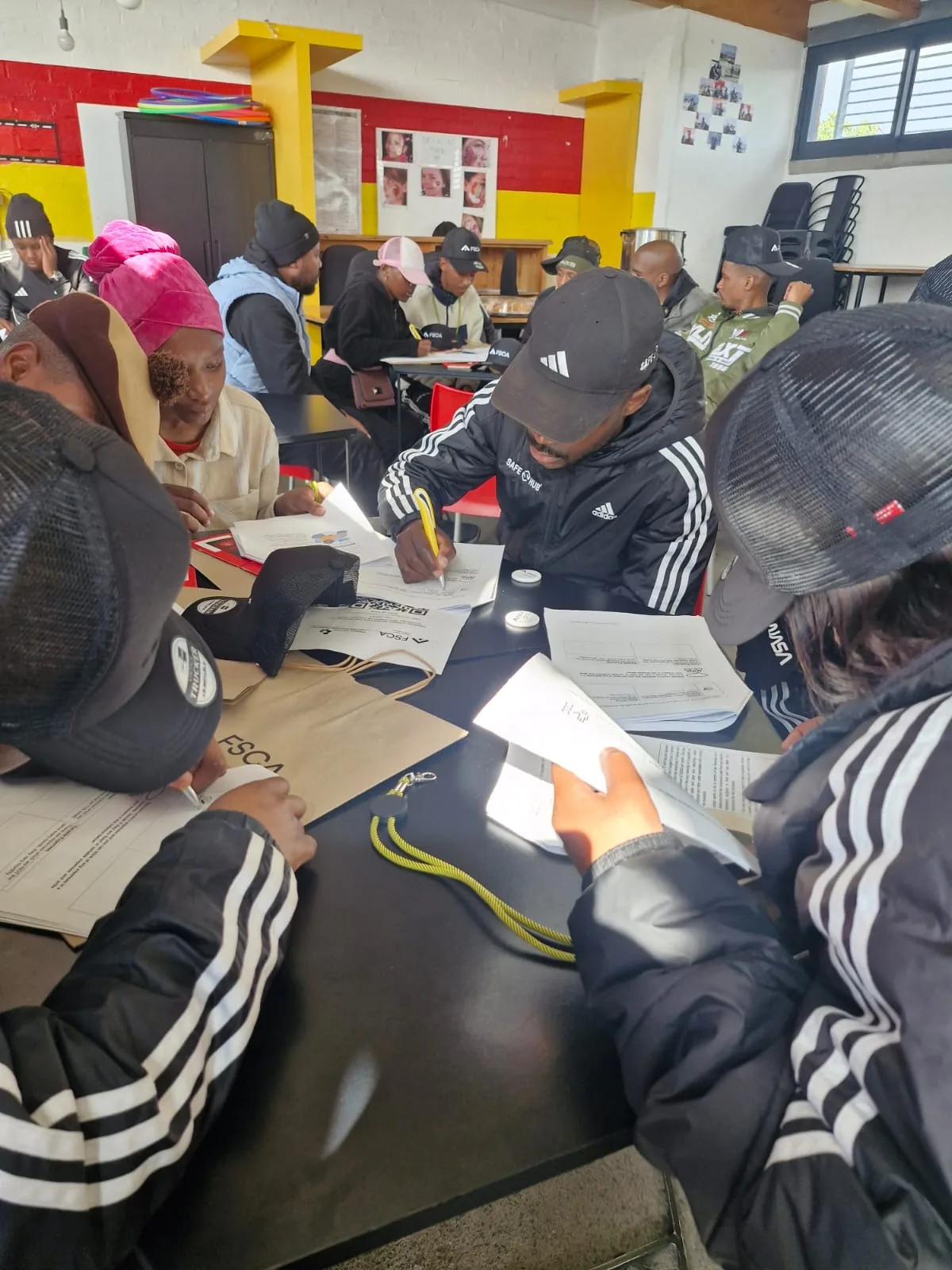 Delegates completing registration forms and FSCA workbooks at a NEET workshop