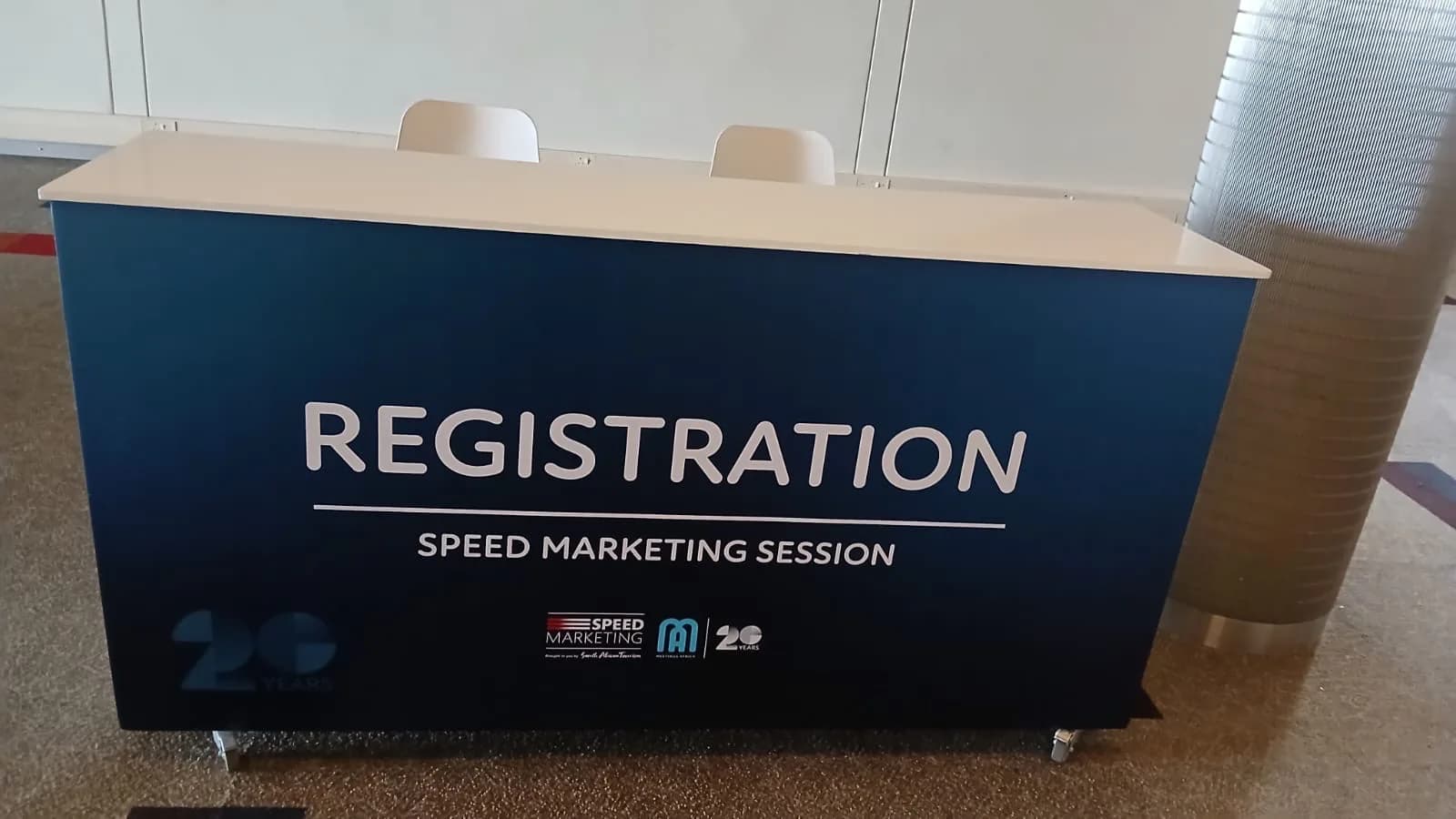 Branded registration counter ready for delegates at the Speed Marketing Session