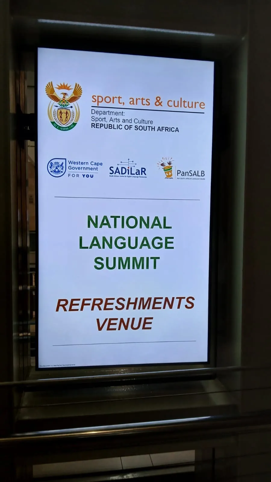 Digital wayfinding signage directing delegates to the National Language Summit refreshments venue
