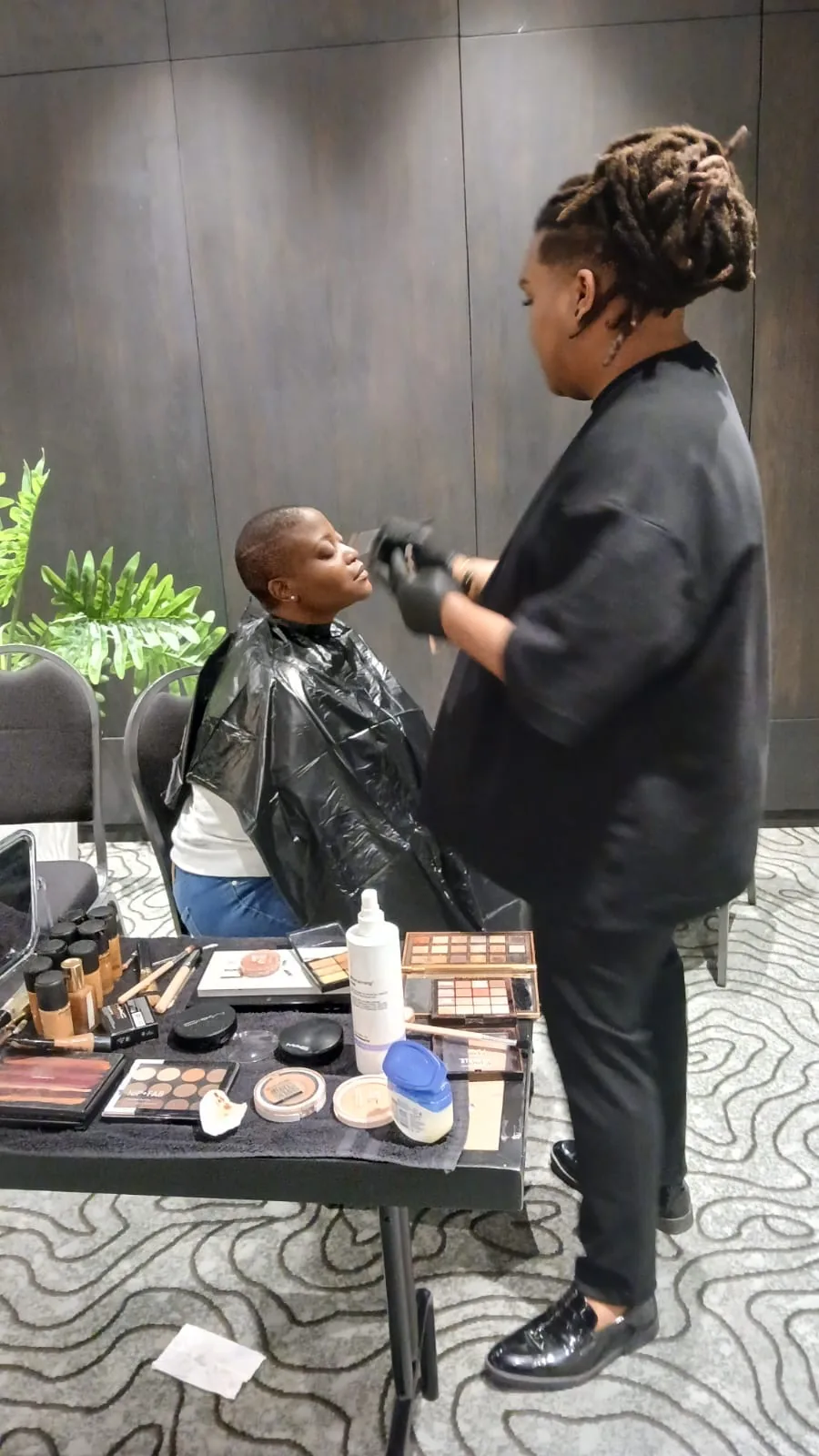 Makeup artist preparing a model backstage ahead of the Afrochic showcase